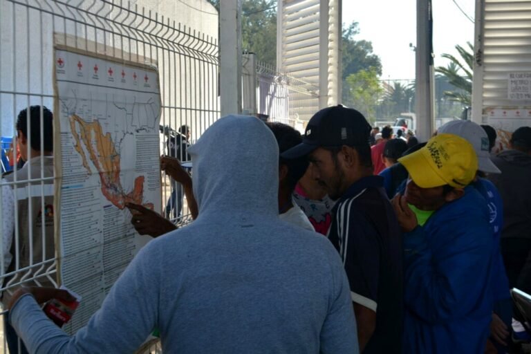 Migrantes consultando un mapa de México en un campamento temporal, Ciudad de México, noviembre de 2018